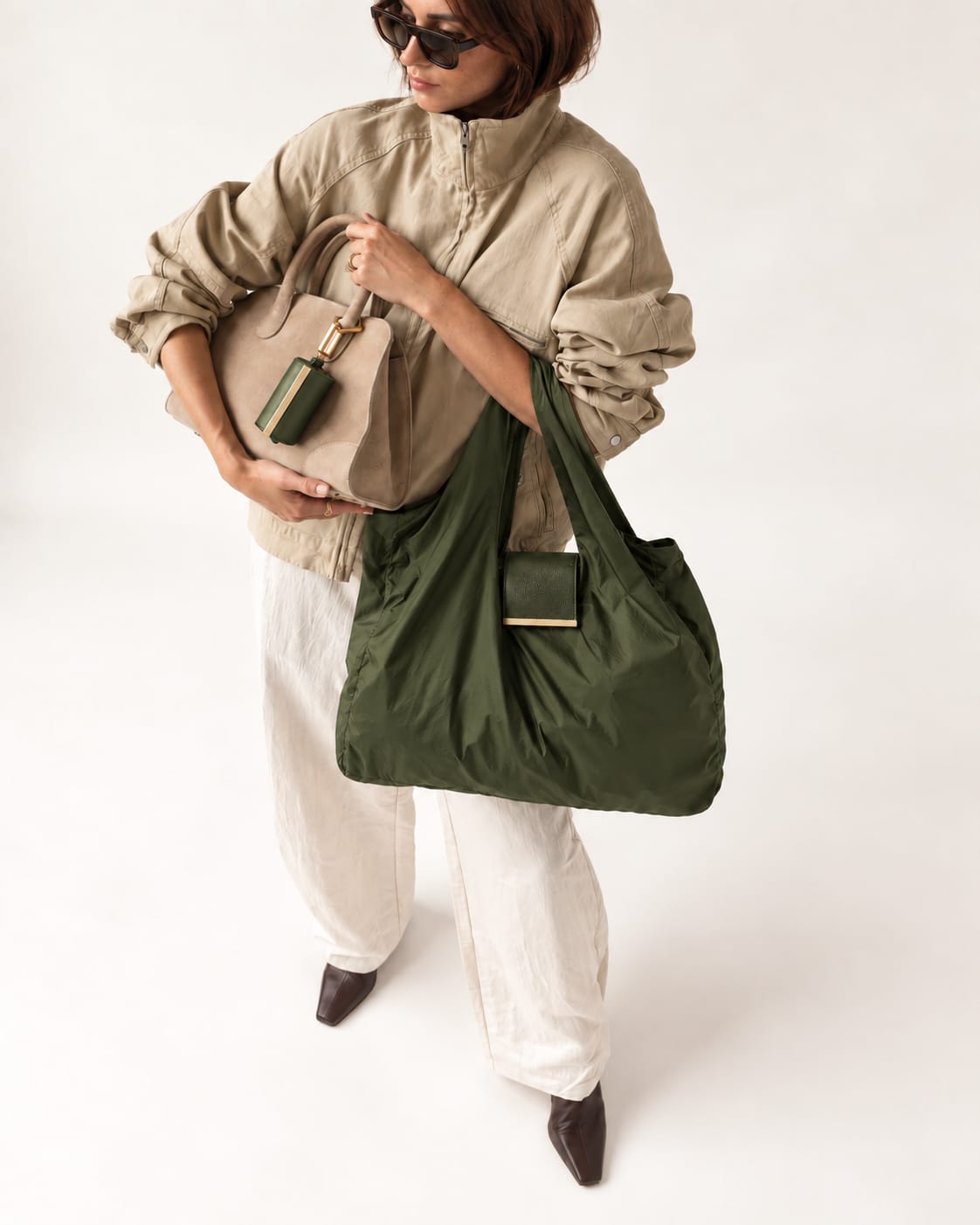 Model met de uitgevouwen Army Green tote en het opgerolde hoesje