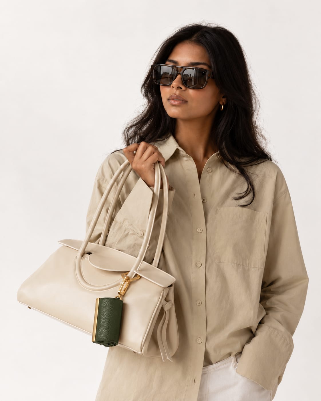 Opgerolde Army Green keychain aan een crème handtas