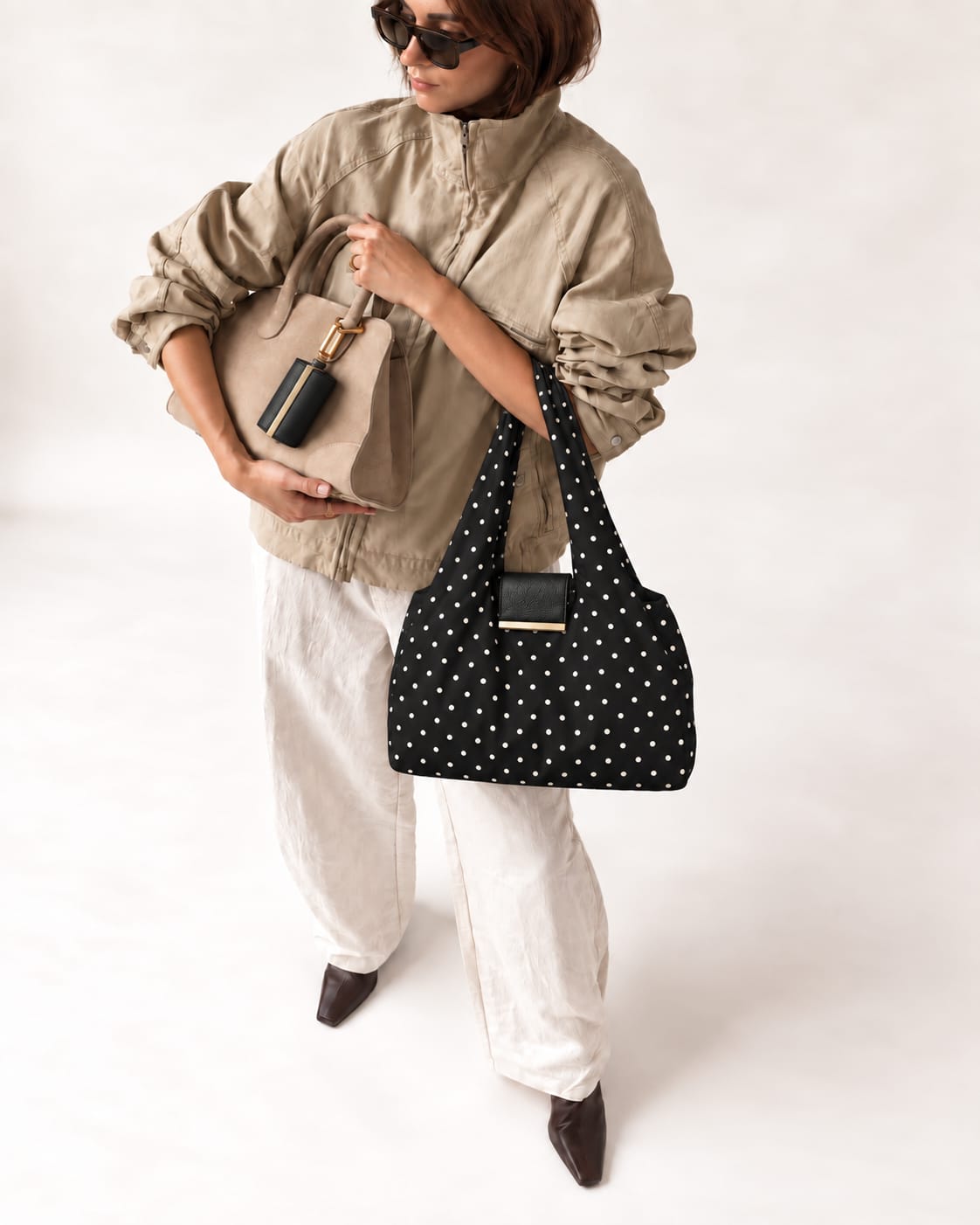 Model met de uitgevouwen Black Polka-dot tote en het opgerolde hoesje