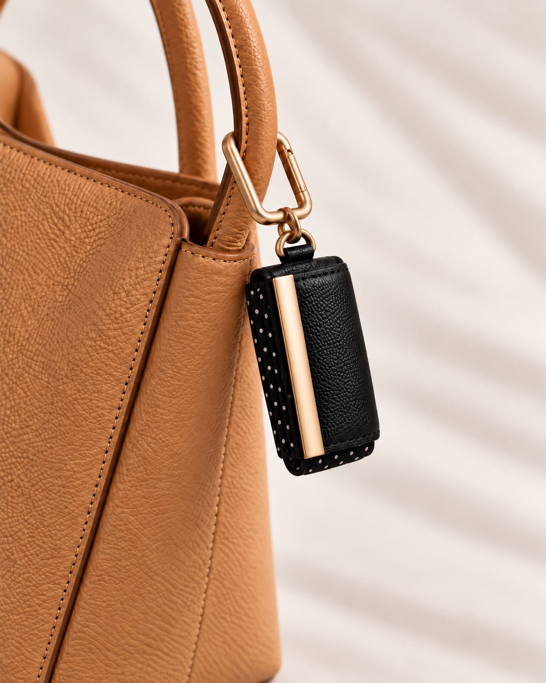 Opgerolde Black Polka-dot keychain aan een cognac handtas, close-up