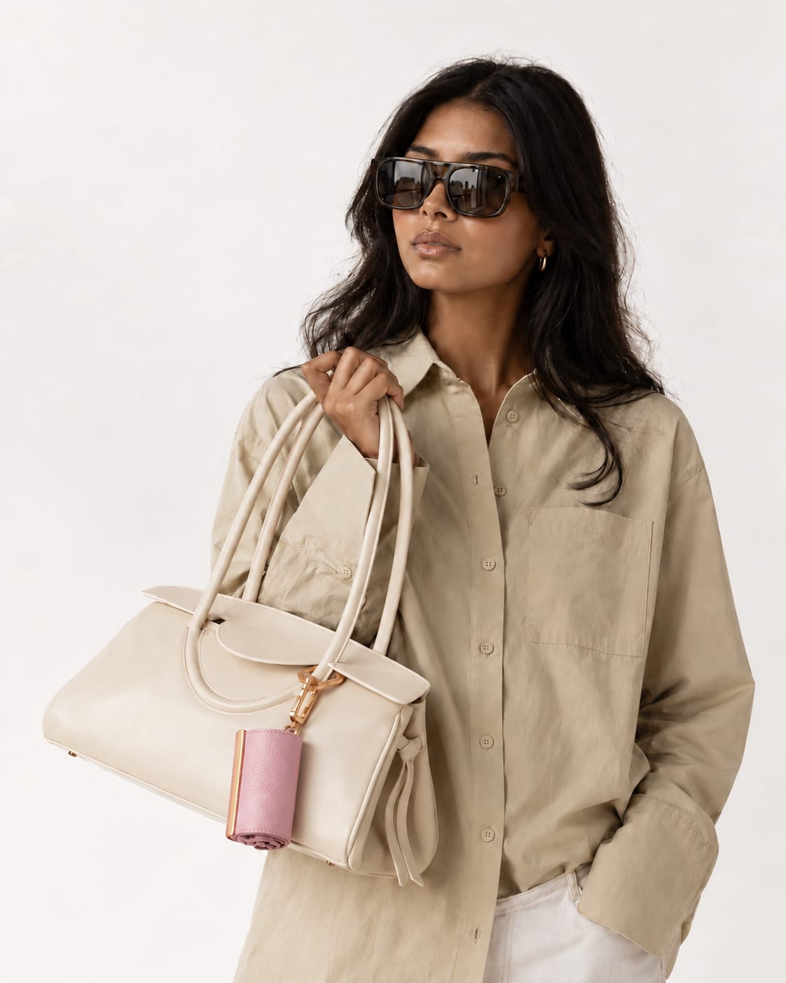 Opgerolde Blush Pink keychain aan een crème handtas