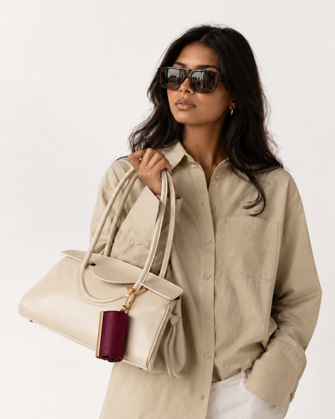 Opgerolde Burgundy keychain aan een crème handtas
