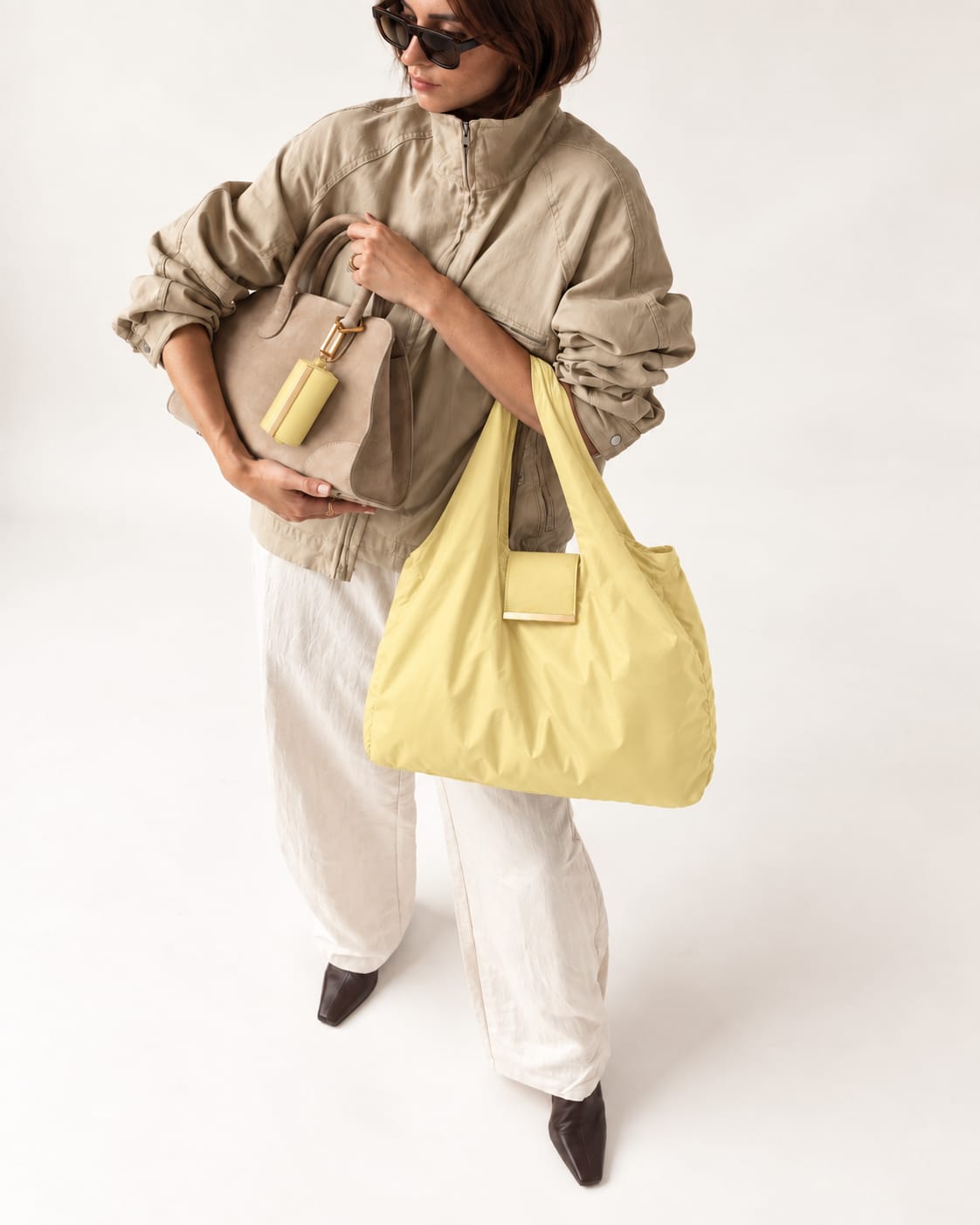 Model met de uitgevouwen Pale Yellow tote en het opgerolde hoesje
