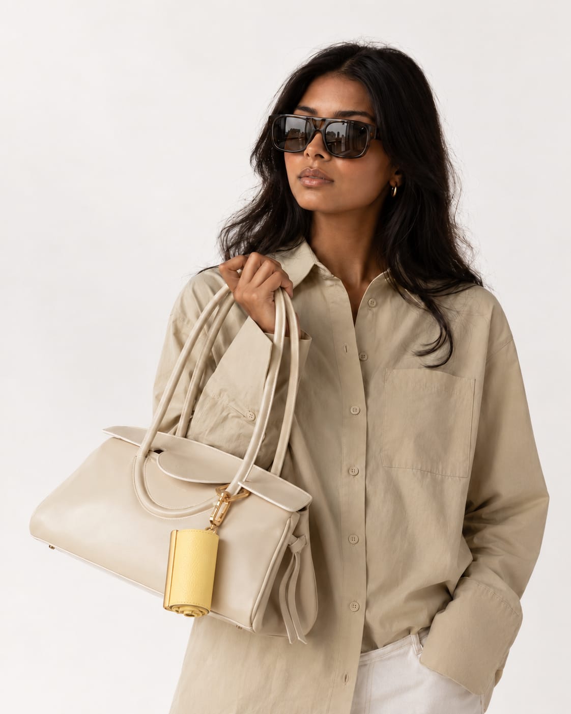 Opgerolde Pale Yellow keychain aan een crème handtas